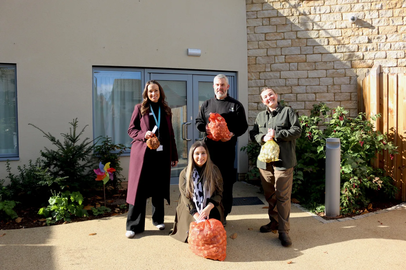 Staff from Johnsons Nurseries and Martin House with sacks of bulbs outside the hospice