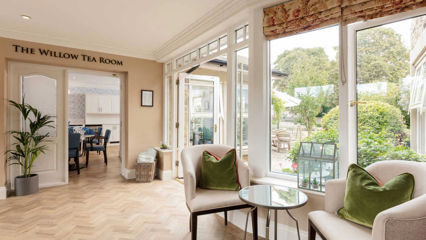 The Willow Tea Room at Wetherby Manor care home, with armchairs by windows onto the garden.